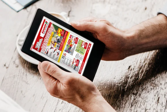 Hände halten einen Tablet-Computer mit einem digitalen Prospekt.